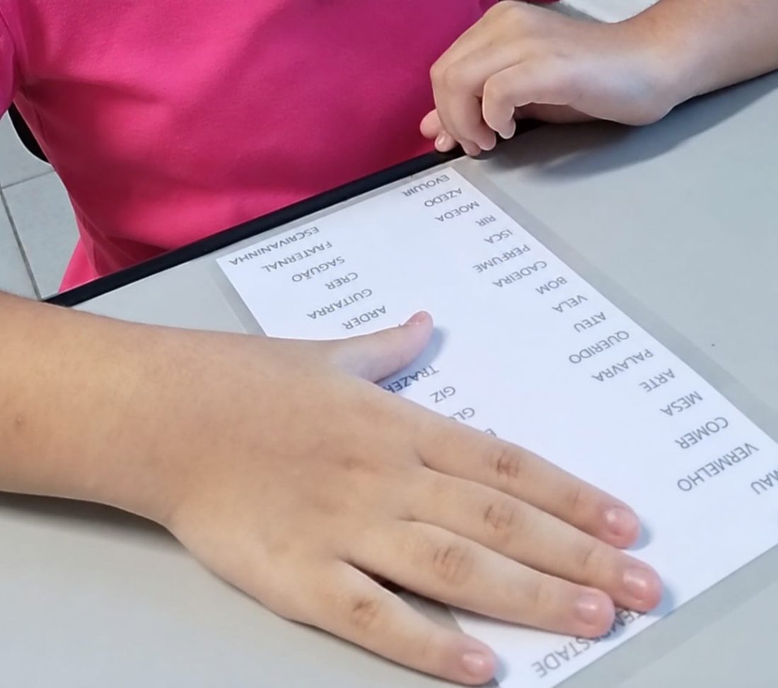 Criança realizando atividade de leitura em sessão de intervenção