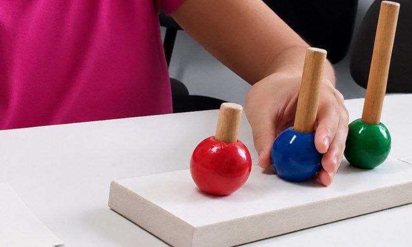 Criança realizando atividade de encaixe de peças coloridas
